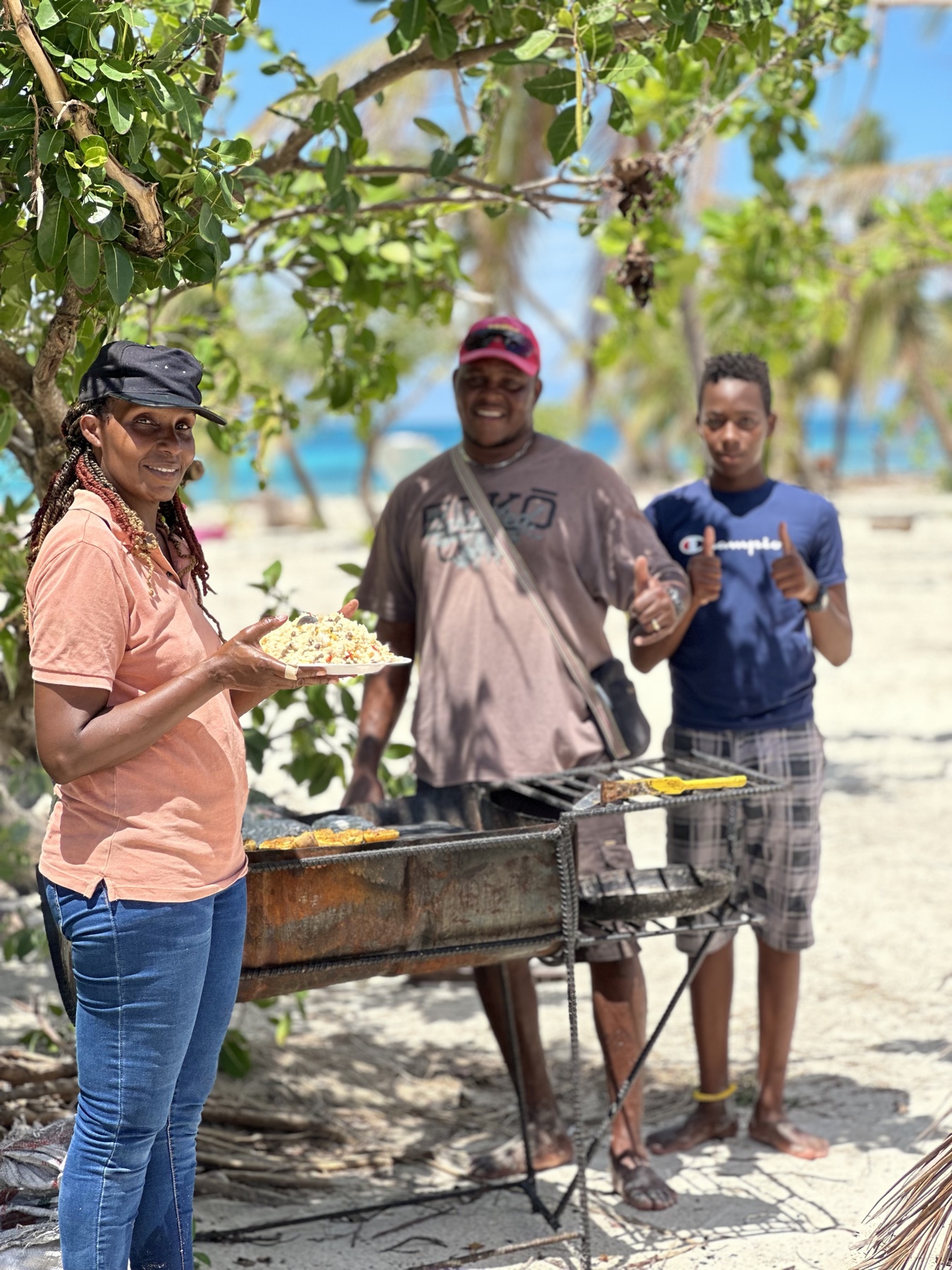 Local Tobago Cays beach BBQ vendors preparing lunch by the water